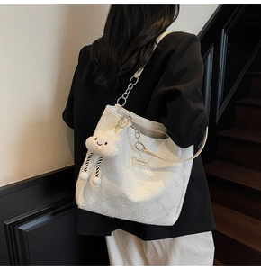 Detail of white textured tote bag featuring a diamond pattern and cute cloud charm
