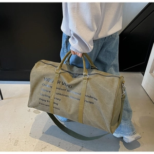 Detailed view of the army green canvas travel bag featuring durable leather handles