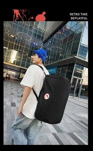 Black nylon cylinder tote bag with adjustable straps and side logo for outdoor travel