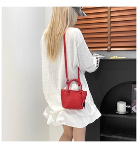 Détails du sac seau rouge à texture litchi avec doubles poignées et charme cœur