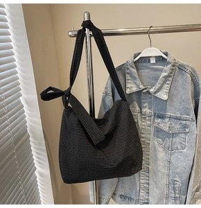 Detail of black checkered canvas tote bag featuring a stylish knotted shoulder strap