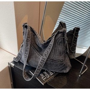 Macro detail of washed denim tote bag with vintage texture and multiple functional pockets
