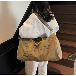 Detail of khaki travel tote with VIGOR VIVID text and olive adjustable strap