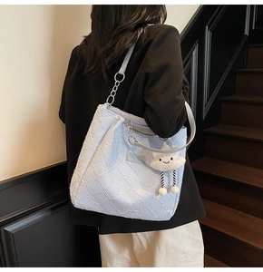Detail of light blue floral jacquard tote bag with stylish chain strap and cloud charm