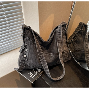 Detail view of retro dark grey washed denim hobo bag with silver metal ring and rivets