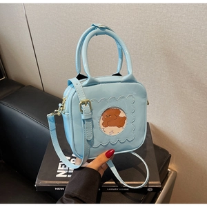 Detail of sky blue glossy PU leather bag with cute puppy illustration window and strap