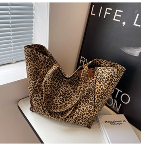 Close-up of leopard print canvas tote bag featuring metal snap buttons and dual handles