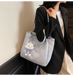 Detail of light blue tote bag featuring 3D floral texture and a cute cloud charm accessory