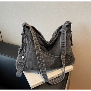 Macro shot of washed gray denim tote bag showing fabric texture and metal buckle detail