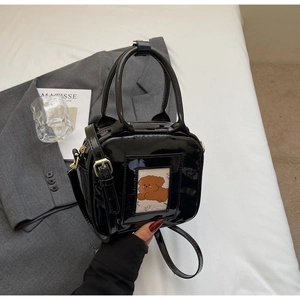 Detail of black patent leather mini square bag with cute cartoon dog card holder