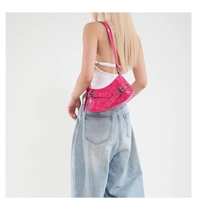 Detail der pinkfarbenen Tasche mit Krokoprägung, Silberschnallen und Y2K-Ästhetik