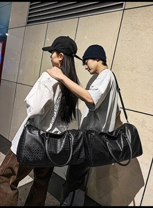 Outdoor shot of large black PU leather travel bags with woven and crocodile textures