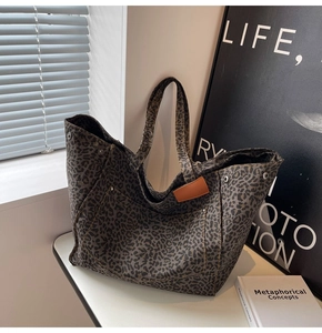 Detail of leopard print canvas tote with leather logo tag and metal rivet studs