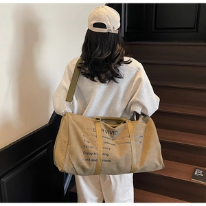 Khaki canvas travel bag with VIGOR VIVID print shown on model in a modern lifestyle setting