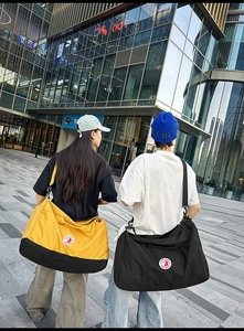 Nylon tote bags in yellow and black shown by models on a city street backdrop