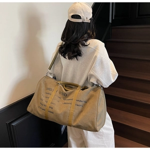 Detailed view of khaki canvas travel tote with dual handles and motivational branding
