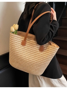 Handwoven straw tote bag with brown leather straps and textured wave pattern for summer
