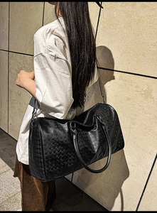 Detail of black houndstooth embossed travel tote bag with detachable shoulder strap