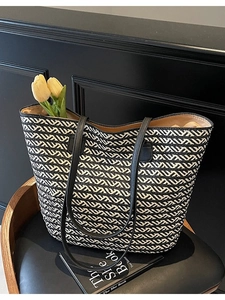 Minimalist black and white woven straw tote bag with premium leather shoulder straps