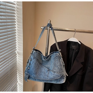 Detail of vintage denim tote bag with metal rivets, top stitching and cargo pocket
