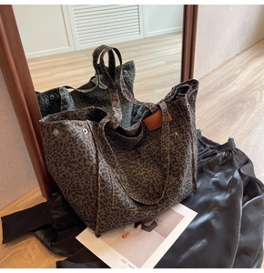 Detail of leopard print canvas tote featuring metal rivets and leather label accents