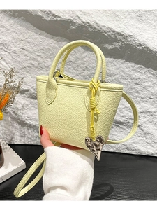 Sac seau en cuir jaune pâle avec breloque cœur argentée et bandoulière fine