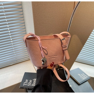 Détail du sac seau rose avec texture plissée et pendentif en forme de cœur argenté