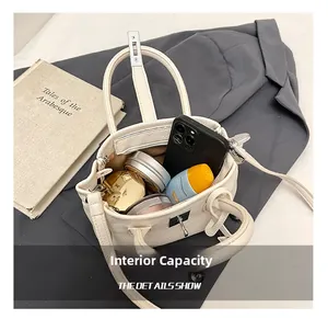 Internal view of a white bucket bag showing capacity for phone and cosmetics