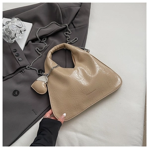 Close-up of beige pleated dumpling bag with silver chain and heart charm detail