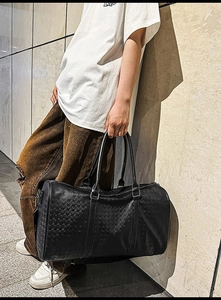 Detail of black large travel tote with houndstooth embossed PU leather and metal D-rings