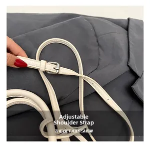 Macro detail of white lychee leather adjustable shoulder strap with silver metal buckle