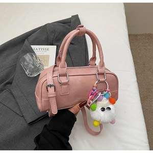 Detail of pink bowling handbag with fluffy monster pendant on a minimalist background