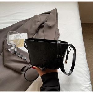 Détail du sac seau noir plissé brillant avec bandoulière réglable et gaufrage Fashion
