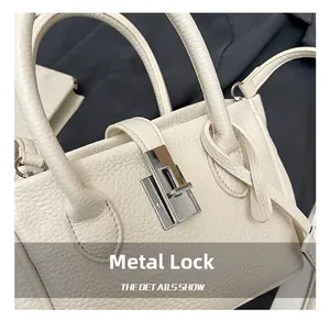 Detail of silver hardware buckle on premium off-white lychee grain leather handbag