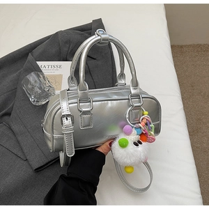 Close-up of silver Boston bag featuring metallic texture and colorful plush pendant