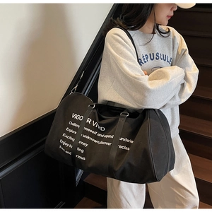 Macro shot of durable black canvas travel bag with white motivational text and logo