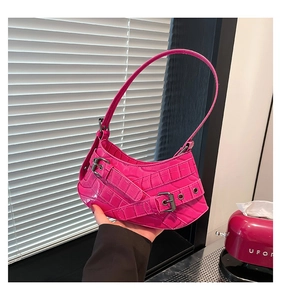 Detailansicht der pinkfarbenen Schultertasche mit Kroko-Prägung und Punk-Metallschnallen