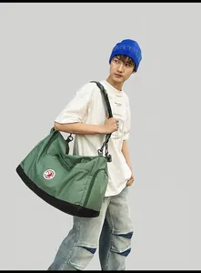 Close-up of olive green nylon tote bag with black accents and white brand logo