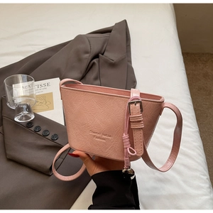 Détail du sac seau rose en cuir plissé avec pendentif boule métallique argentée stylé