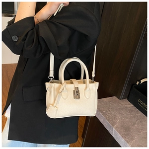 Detail of white lychee grain leather mini bucket bag with silver lock and detachable strap
