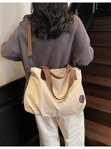 Waterproof large capacity travel tote bag in beige canvas with brown shoulder strap