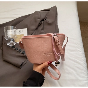 Détails de sac seau rose en cuir craquelé avec breloque en forme de cœur
