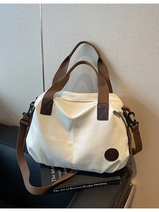 Waterproof large capacity cream canvas travel bag with brown straps and logo