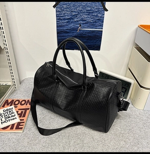 Detail of black woven texture Boston bag with dual handles and detachable nylon strap