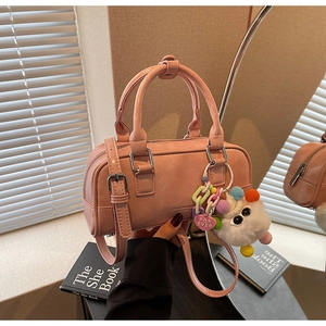 Pink bowling bag with adjustable strap and a cute plush monster charm detail