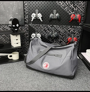 Macro detail of dark grey nylon tote bag with reinforced base and red circular logo