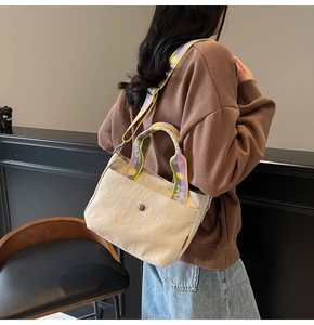 Detailansicht der beigen Canvas-Tasche mit lila und gelbem Kontrast-Schultergurt