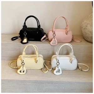 Vue détaillée de mini sacs polochons en quatre couleurs avec breloques miroir cœur