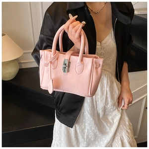 Close-up of pink lychee grain leather bucket bag with silver metal twist lock closure