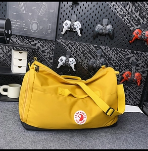 Macro shot of large-capacity yellow waterproof nylon bag with reinforced handles and logo